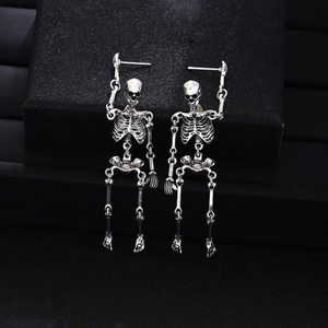 Detailed close-up of antique silver skeleton earrings featuring blue gauze accents on black