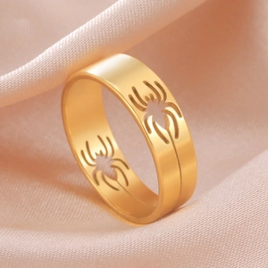Macro detail of golden spiderweb hollow ring on soft champagne satin fabric