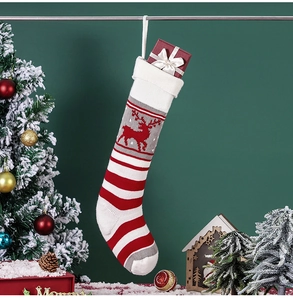 Close-up of a knitted Christmas stocking with reindeer patterns and festive gift box inside