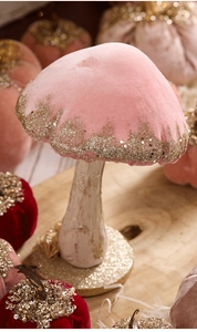 Close-up of velvet mushroom ornament with golden glitter edges and textured wood base