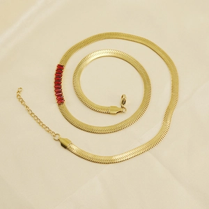 Vintage 18K gold plated snake chain necklace with red gemstone on beige silk background