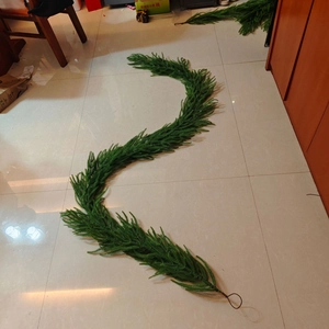Detailed view of artificial green pine garland with metal hooks for Christmas decoration