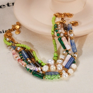 Multilayer natural pearl and colorful stone bracelet with gold beads on beige stand