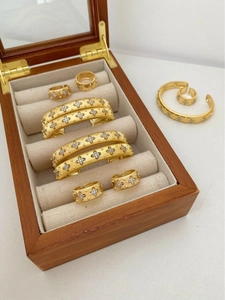 Detailed macro view of brushed gold jewelry set with engraved floral diamond patterns