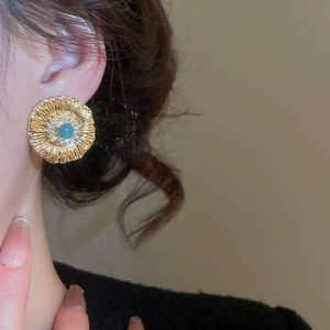 Detailed close-up of vintage sunflower stud earring with turquoise stone and crystals