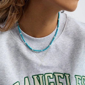 Detail of blue and white beaded necklace worn by a model for professional jewelry showcase