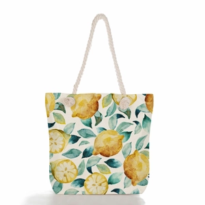 Close-up of lemon print canvas tote with thick rope handles and metallic eyelets