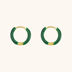 Close-up of emerald green enamel and 18K gold plated hoop earrings in water ripple style