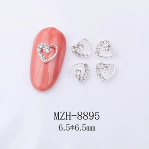 Detail of 6.5mm heart-shaped silver alloy nail art charms with white crystals on pink nails