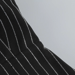 Macro shot of black fabric with vertical shimmering rhinestones for party dress details