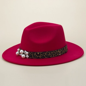 Détail d'un chapeau fedora rose fuchsia avec ruban léopard orné de perles et fleurs