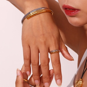 Minimalist two-tone crossover bangle and ring set in 18K gold and silver finish