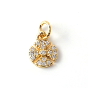 Macro detail of gold plated copper pendant with inlaid zircon cross pattern and ring