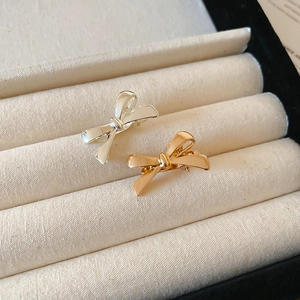 Close-up of gold and silver bow-shaped hair clips with polished metallic finish