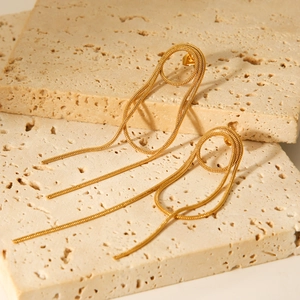 Elegante goldene Quastenohrringe mit feinen Ketten auf Steinplatten, Edelstahlschmuck