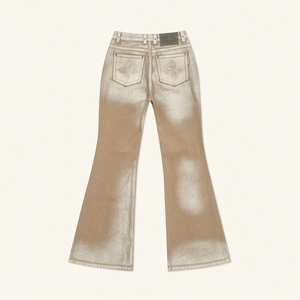 Detail view of flared denim jeans featuring metallic silver coating and back pocket design