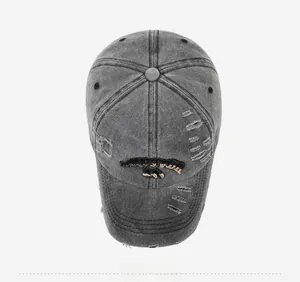 Top view of a gray washed denim baseball cap with distressed details and gold embroidery
