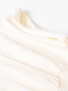 Detailed close-up of cream-white pure wool knitted fabric showing soft pleated textures
