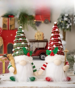 Detail of Christmas gnomes with knit hats, white beards and wooden skis in a festive setting
