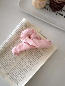 Detail of light pink pleated fabric hair claw set on a magazine for a lifestyle look