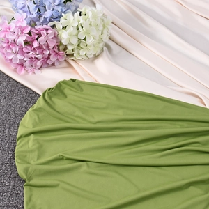 Close-up of grass green knitted fabric texture on off-shoulder bodycon summer dress