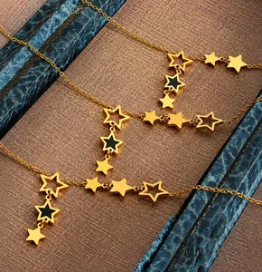Detail of elegant gold star pendant necklace with black enamel and hollow star elements