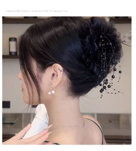 Détail d'une pince à cheveux vintage fleur noire en mesh avec pompons perlés élégants
