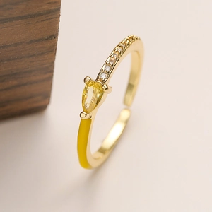 Detail of 18K gold ring featuring pear-cut yellow gem and yellow enamel inlay accents