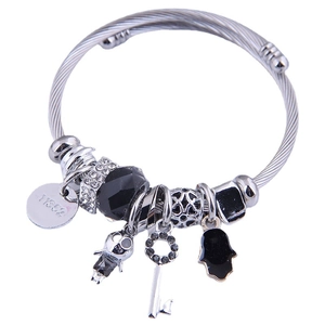 Silver twisted bangle with diverse charms including a bear disc and paved key pendant