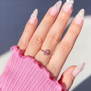 Detail of rose gold chain-link ring with an oval pink zircon on a finger