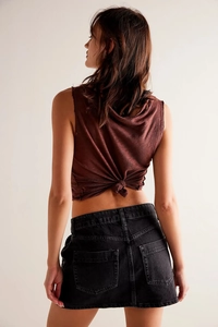 Détail du haut marron dos nu et de la jupe en jean noire avec texture de coton premium