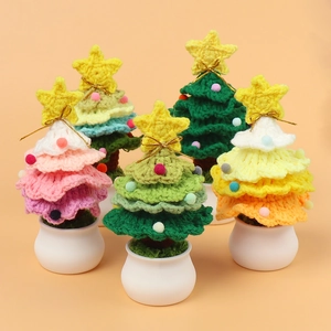 Close-up of five handmade crochet Christmas tree pots with colorful wool pom-poms