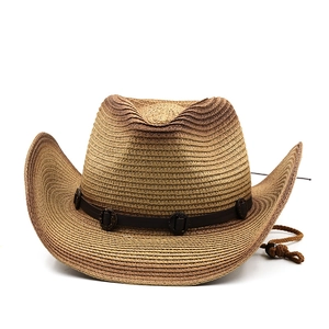 Detail of straw cowboy hat featuring a leather band with rustic buckle and chin strap