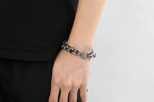 Vue détaillée des maillons de crâne en argent et du fermoir texturé sur un poignet