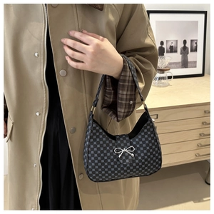 Detail of crescent shoulder bag with geometric dot pattern and silver bow decoration