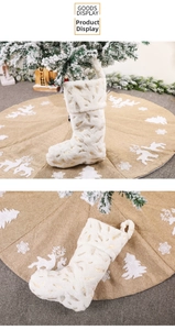 Detail of plush white Christmas stocking with golden feather print on festive background