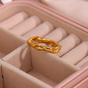 Detail of gold plated ring with irregular lava texture in a pink velvet jewelry box