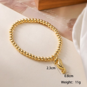 Detailed view of a gold beaded bracelet featuring a seahorse charm with dimensions and weight