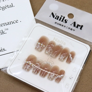 Press-on nail set featuring pearl accents and brown gradient patterns in packaging