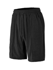 Detail view of black sports shorts featuring geometric jacquard fabric and metal tip drawstring