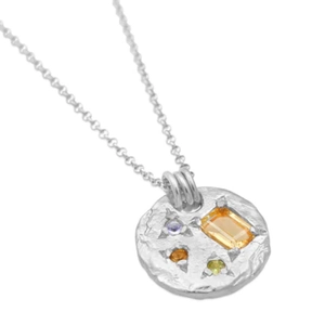 Macro detail of silver necklace pendant with colorful crystals and irregular texture