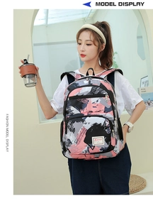 Detail view of pink and black graffiti print backpack with Sport label worn by a model