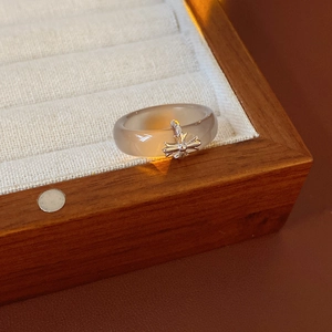 Detail of translucent gray chalcedony ring with a silver metal cross in a wooden box