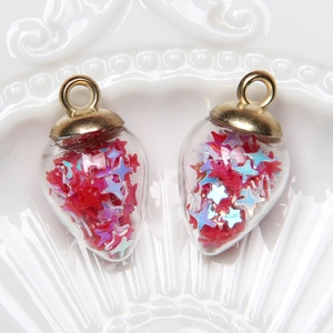Detail of teardrop glass pendants filled with red and blue star sequins and gold caps
