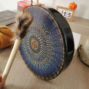 Macro detail of shamanic drum with colorful mandala pattern and fur-tipped wooden mallet