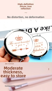 Close-up of portable round metal makeup mirror with crown logo and foldable dual mirror detail