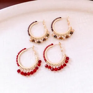 Ethnic style golden hoop earrings with woven cord and faceted glass bead pendants