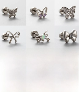 Macro detail of six silver titanium steel butterfly ear studs with zircon and screw backs