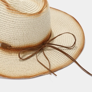Nahaufnahme von Cowboy-Strohhut mit dunkelbraunem Farbverlauf und Lederband-Verzierung