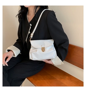 Detailed view of white pleated leather crossbody bag with elegant gold metal buckle